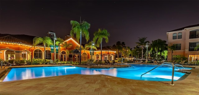 pool at twilight featuring a patio area