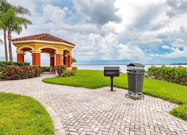 view of community with a gazebo, a water view, and a lawn