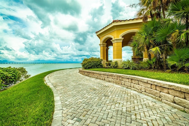 view of property's community featuring a water view and a lawn