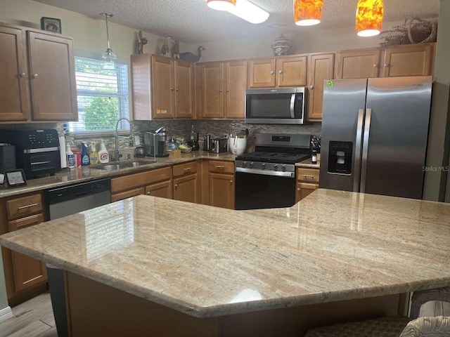 kitchen featuring stainless steel appliances, tasteful backsplash, sink, a breakfast bar, and hanging light fixtures