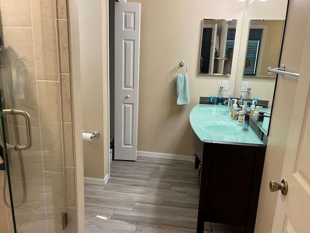 bathroom featuring a shower with door, vanity, and wood-type flooring