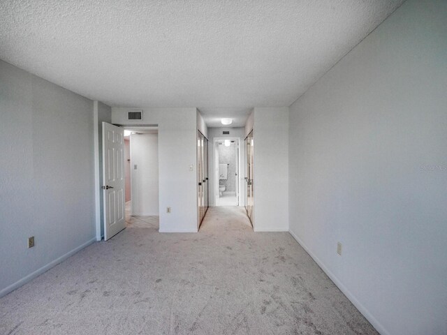 carpeted spare room with a textured ceiling