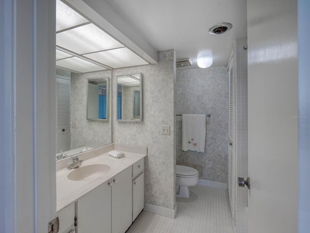 bathroom with vanity, toilet, and tile patterned flooring