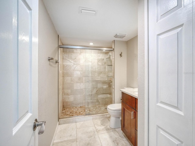 bathroom featuring vanity, toilet, and a shower with shower door