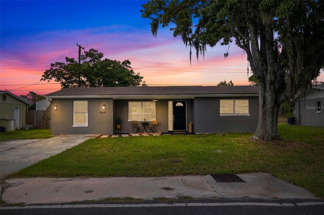 ranch-style house featuring a yard and central AC