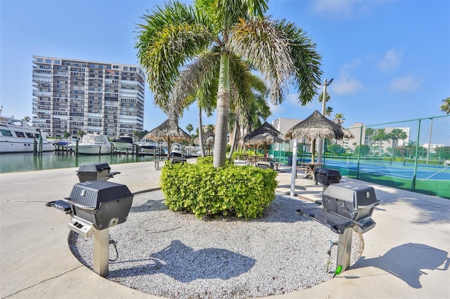 view of home's community featuring a gazebo, a water view, and tennis court