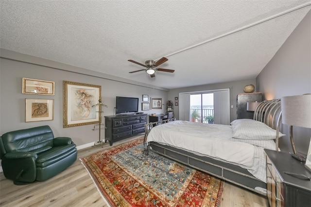 bedroom featuring ceiling fan, hardwood / wood-style flooring, and a textured ceiling