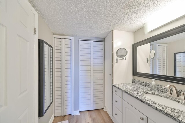 bathroom with vanity, hardwood / wood-style flooring, and a textured ceiling