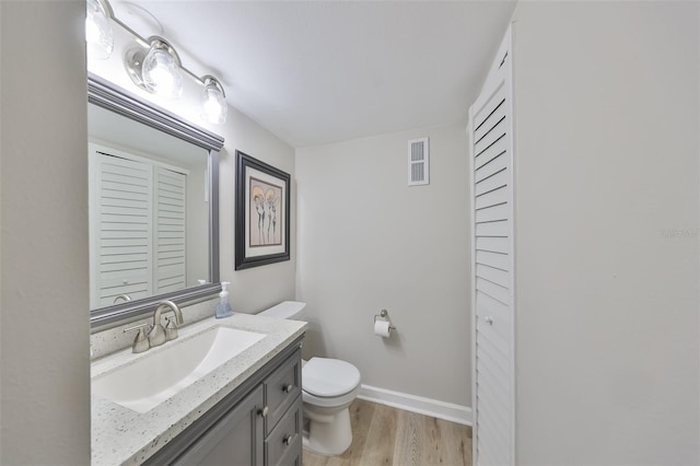 bathroom featuring vanity, toilet, and hardwood / wood-style floors