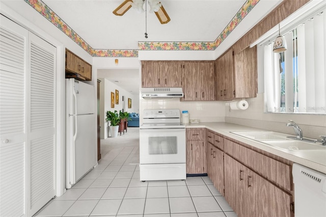 kitchen featuring sink, light tile patterned floors, ceiling fan, and white appliances