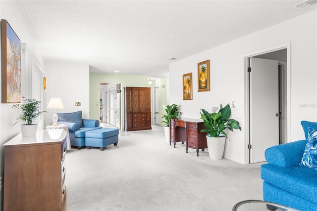 living room featuring light carpet and a textured ceiling