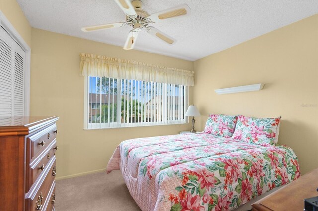 bedroom with light carpet, a textured ceiling, a closet, and ceiling fan