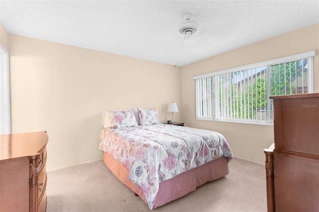 bedroom featuring light colored carpet and ceiling fan