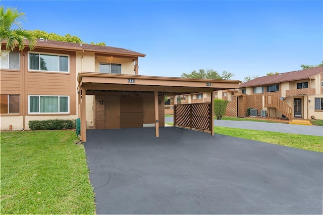 view of front of home featuring a carport, a front yard, and cooling unit