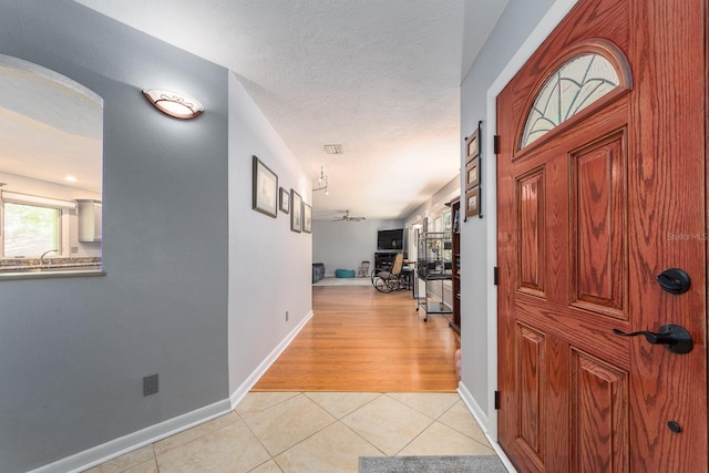 tiled entrance foyer with a textured ceiling and sink