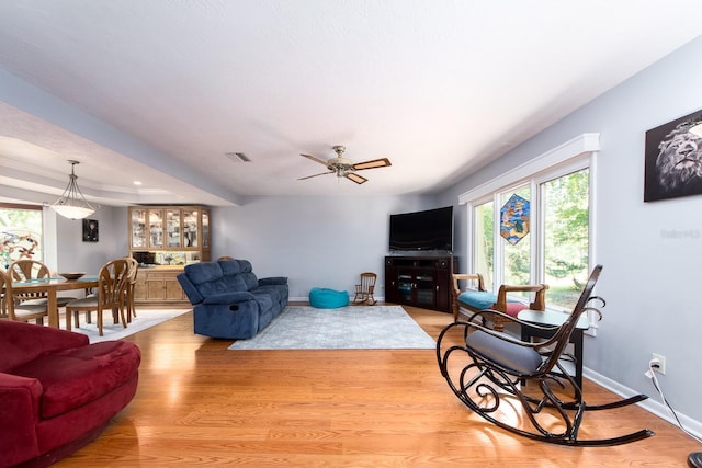 living room featuring light wood-type flooring and ceiling fan