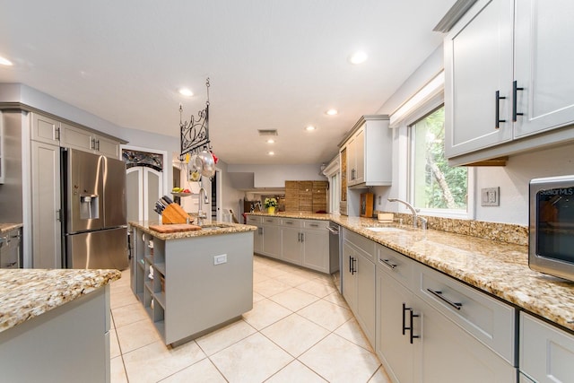 kitchen with gray cabinetry, appliances with stainless steel finishes, sink, and a kitchen island