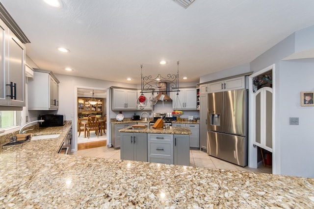 kitchen with gray cabinetry, light tile patterned flooring, a center island, and stainless steel appliances