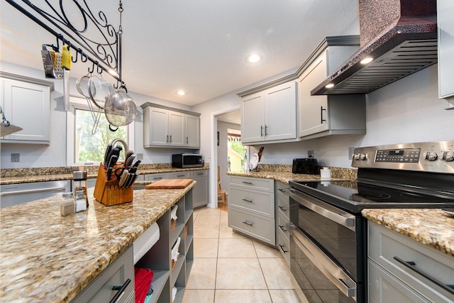 kitchen featuring gray cabinets, wall chimney exhaust hood, stainless steel appliances, and plenty of natural light