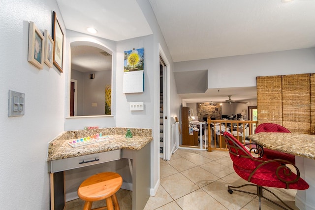 kitchen featuring light stone countertops, ceiling fan, and light tile patterned flooring