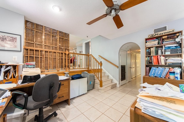 office area with a textured ceiling, light tile patterned floors, and ceiling fan