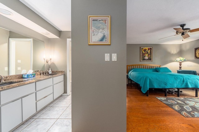 bedroom featuring ceiling fan, light tile patterned flooring, and sink