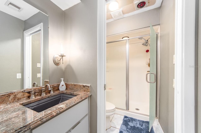 bathroom with tile patterned floors, a shower with door, vanity, and toilet