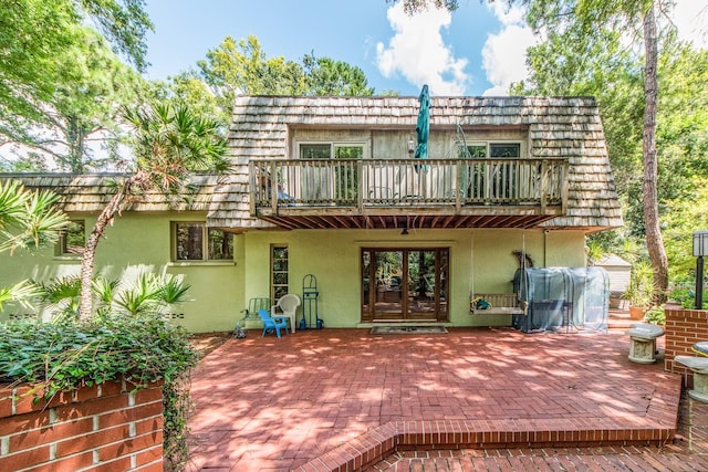 back of house featuring a balcony, a patio area, and french doors