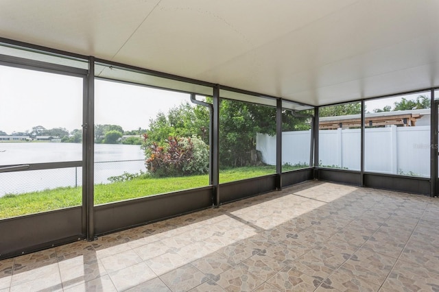 unfurnished sunroom featuring plenty of natural light and a water view