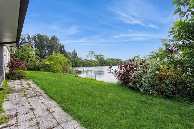 view of yard with a water view and fence