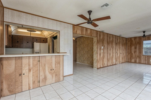 kitchen with visible vents, ceiling fan, ornamental molding, white fridge with ice dispenser, and a textured ceiling