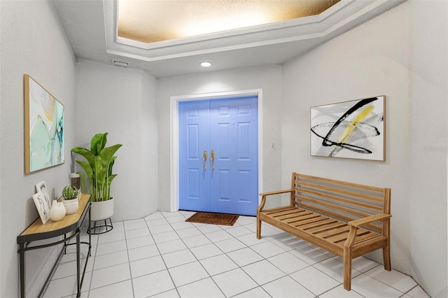 tiled foyer entrance with a raised ceiling