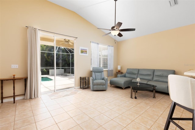 living room with ceiling fan, lofted ceiling, and light tile patterned floors