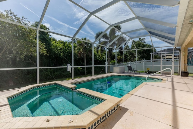 view of swimming pool with a patio, an in ground hot tub, and a lanai