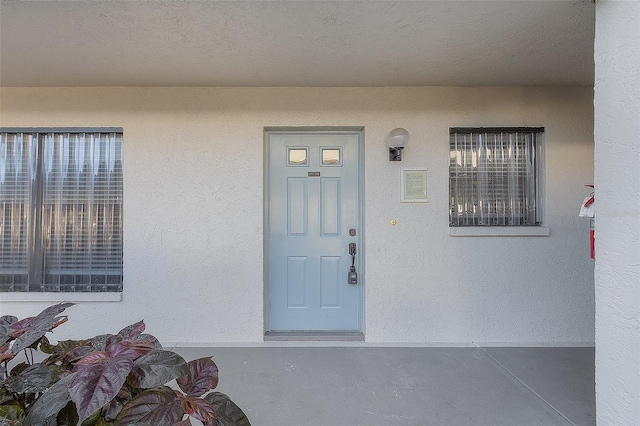 doorway to property featuring stucco siding