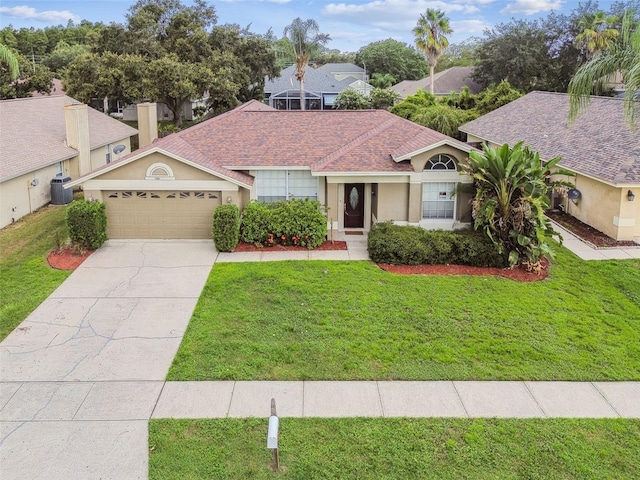 view of front of house with a garage, cooling unit, and a front yard