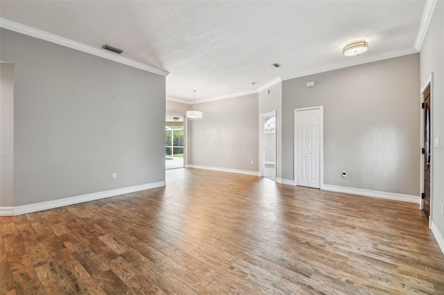 unfurnished room featuring ornamental molding, a textured ceiling, and hardwood / wood-style floors