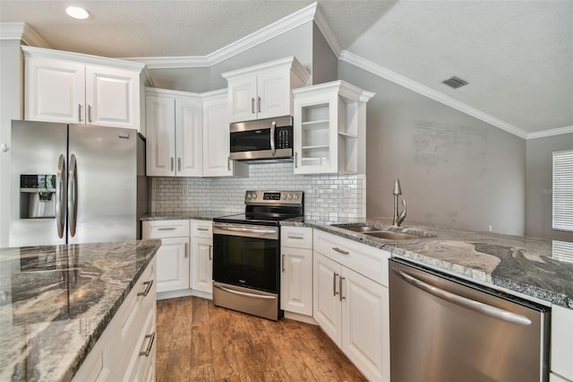 kitchen featuring appliances with stainless steel finishes, wood-type flooring, crown molding, and sink