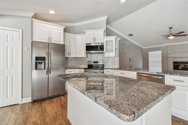 kitchen featuring white cabinets, dark wood-type flooring, ceiling fan, appliances with stainless steel finishes, and ornamental molding