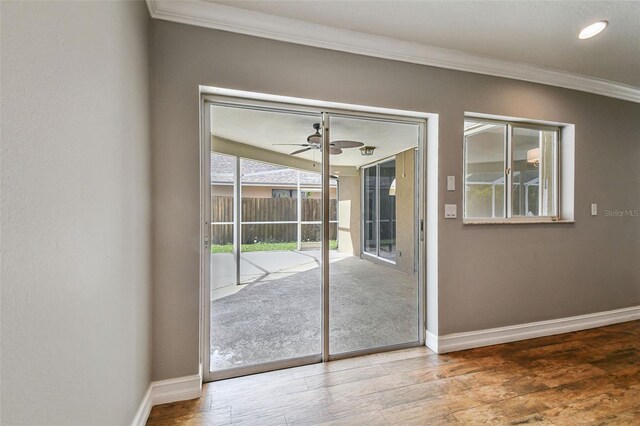 doorway featuring crown molding, ceiling fan, and wood-type flooring