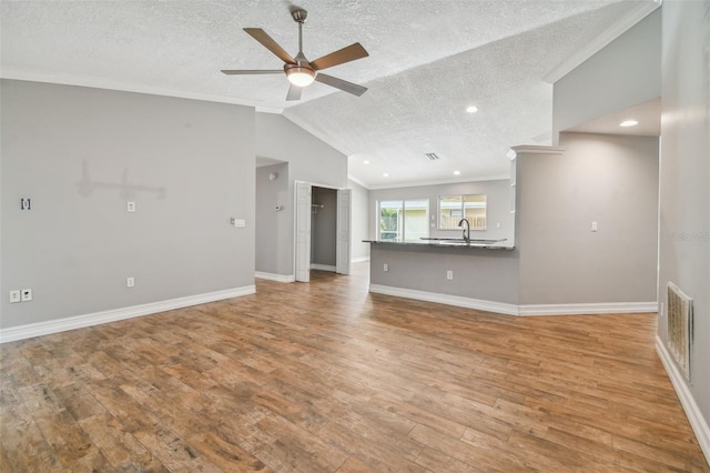 unfurnished living room featuring light hardwood / wood-style flooring, lofted ceiling, and crown molding