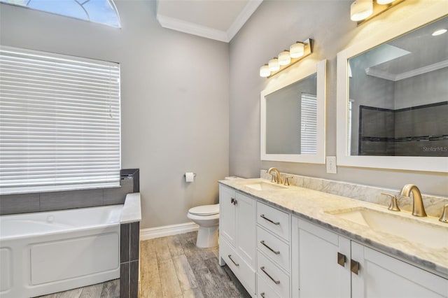 bathroom with double sink vanity, toilet, a bathing tub, hardwood / wood-style flooring, and ornamental molding