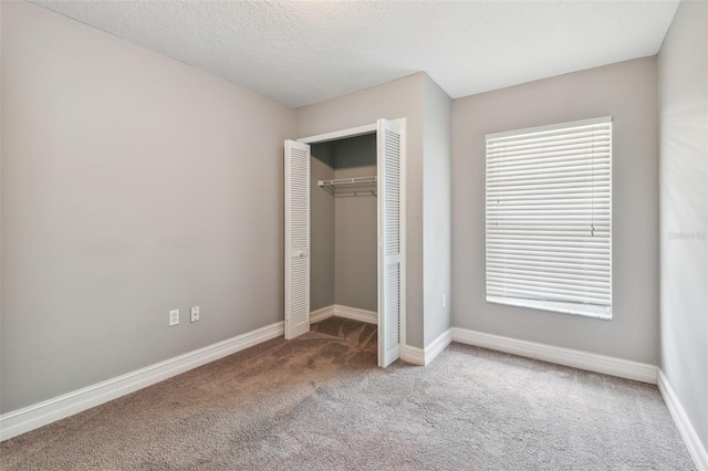 unfurnished bedroom with a closet, carpet, and a textured ceiling