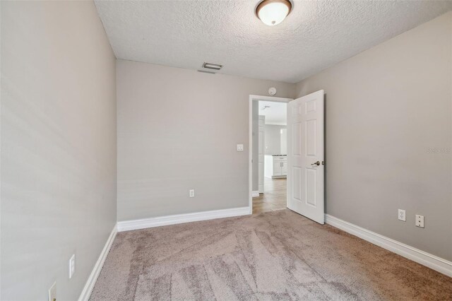 carpeted spare room with a textured ceiling