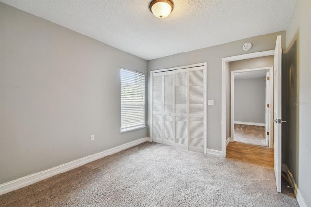 unfurnished bedroom with a closet, carpet flooring, and a textured ceiling