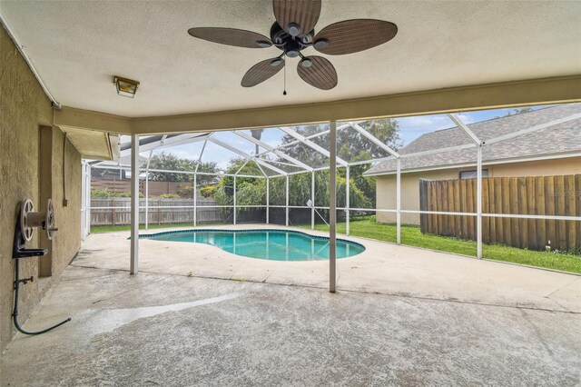 view of pool featuring a patio, a yard, ceiling fan, and glass enclosure