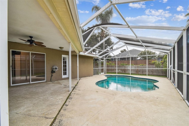 view of swimming pool with a patio area, ceiling fan, and glass enclosure