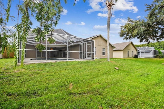 back of property featuring a patio area, a yard, and glass enclosure