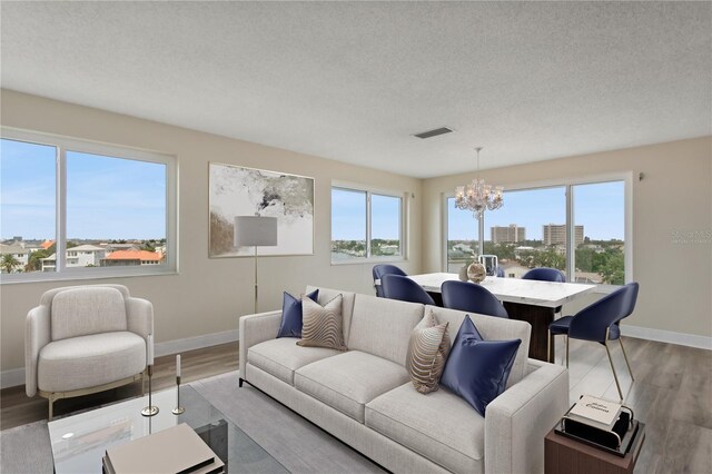 living room featuring hardwood / wood-style floors, a notable chandelier, and a healthy amount of sunlight