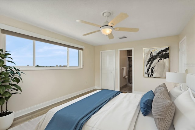 bedroom featuring ceiling fan, a closet, connected bathroom, and hardwood / wood-style floors